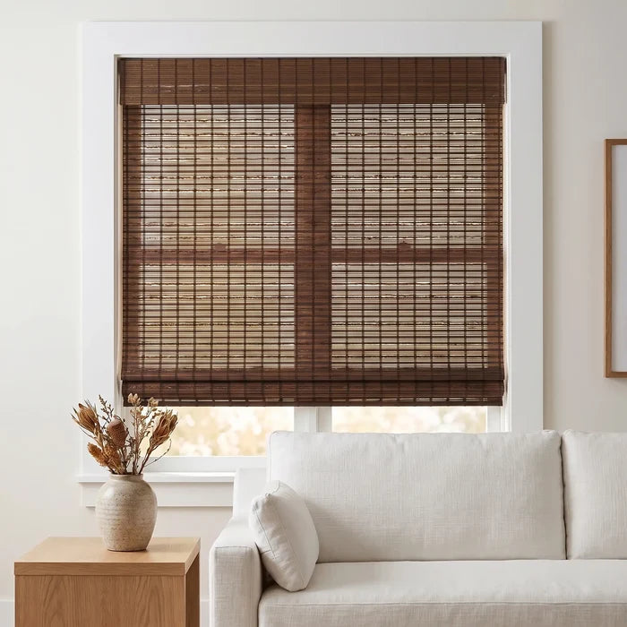 Transform your space with Cordless Woven Wood Shades, effortlessly filtering natural light into a warm and inviting atmosphere, like this serene living room featuring plush furniture.