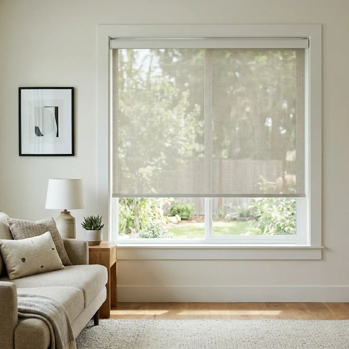 Front-facing view of a cream-colored Natural solar shade with 14 percent openness, providing light filtering and UV protection in a bright sitting area.