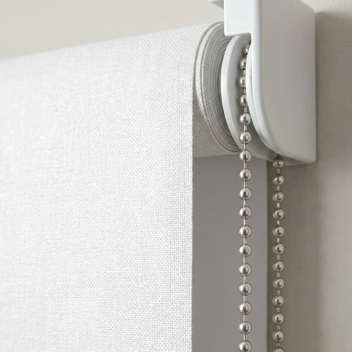 Close-up detail of the white Luxe fabric blackout roller shade top mechanism and mounting bracket, highlighting the clean, modern hardware