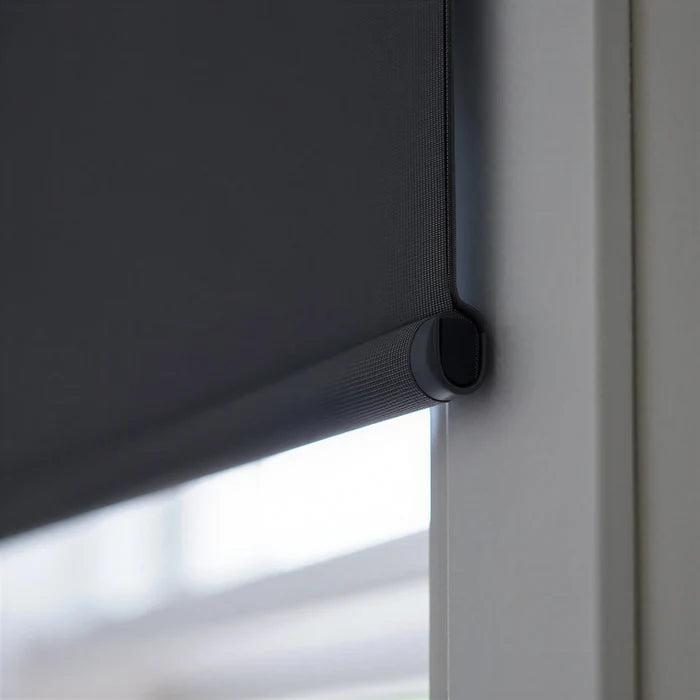 Extreme macro close-up of the black fabric-wrapped hem bar on a ProGrade blackout roller shade, showing the premium finish.