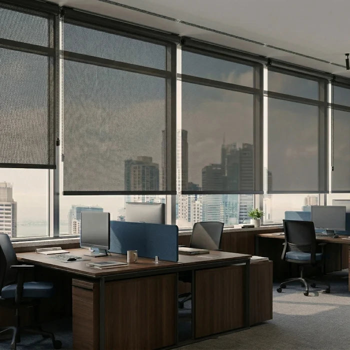 Multiple black ProGrade solar roller shades installed in a modern commercial office with city views.