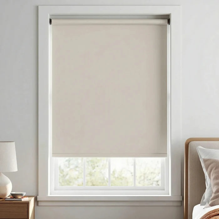 Alternative view of crisp white Spunwhite blackout roller shades in a bright bedroom with neutral decor.