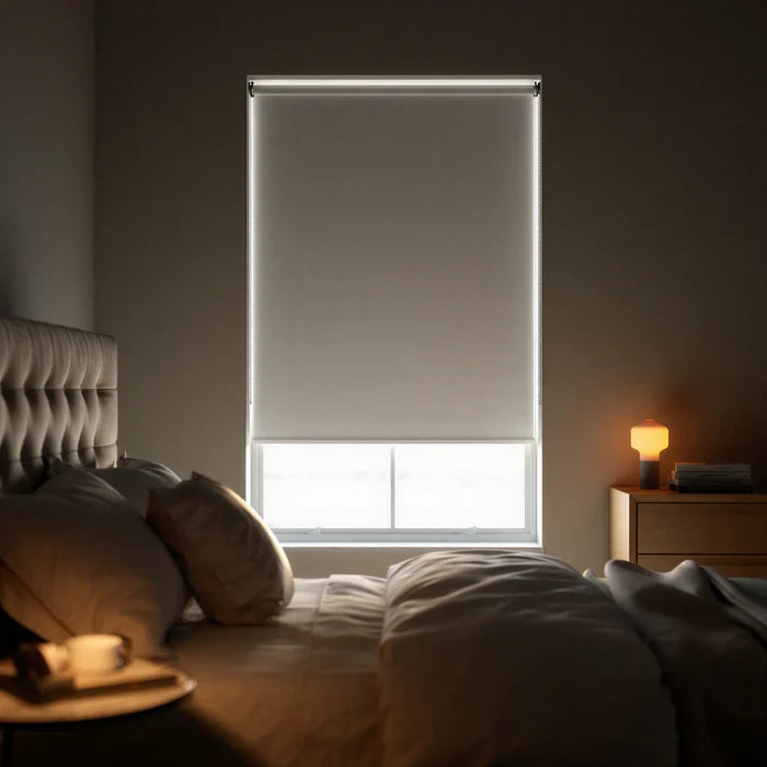 Main front view of a black signature blackout roller shade providing total light blockage in a modern bedroom.