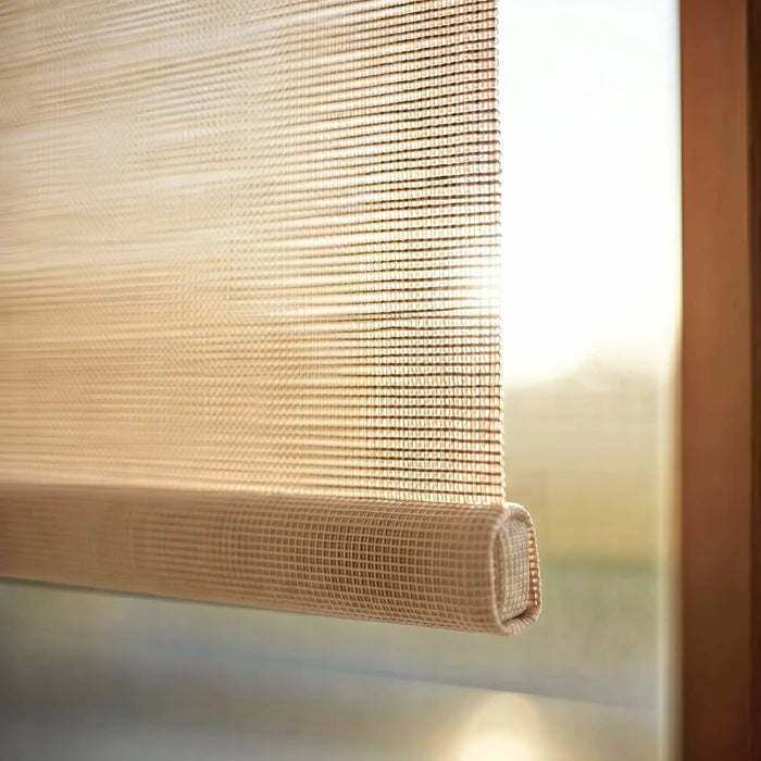Detailed view of the decorative fabric-wrapped hem bar on a tan Sandstone Signature solar roller shade.