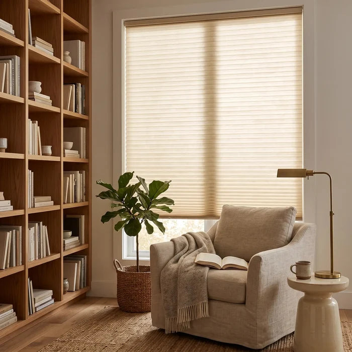 Simplistic Cordless Pleated Shades' soft beige hue harmonizes with wooden furniture, white walls, and book-lined shelves in this inviting study, creating a warm and intelligent atmosphere.