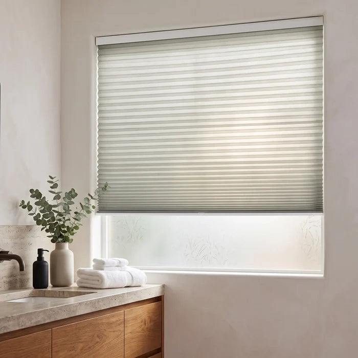 Simplistic Cordless Pleated Shades in Creamy white adorn this modern bathroom, perfectly balancing the wooden vanity's warm tones and sleek sink area.