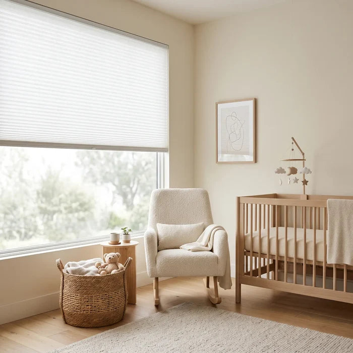 Simplistic Cordless Pleated Shades create a serene ambiance in this peaceful nursery, where a white shade effortlessly blocks out outside light and allows for gentle illumination.