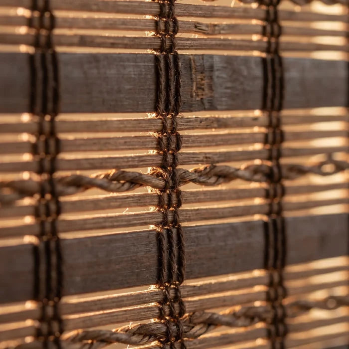 Macro Closeup shot of earthly brown Woven Wood Shades, effortlessly filtering sunlight with warm wood accents showcasing adjustable privacy and versatile lighting.