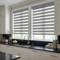 Zebra Room Darkening Roller Shades provide soft gray filtering in modern kitchens, while blocking light and maintaining elegant style with these window treatments.