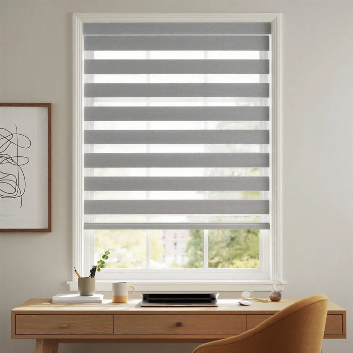 Elegant gray and white striped Zebra Room Darkening Roller Shades adorn this cozy living space, perfect for working or relaxing.